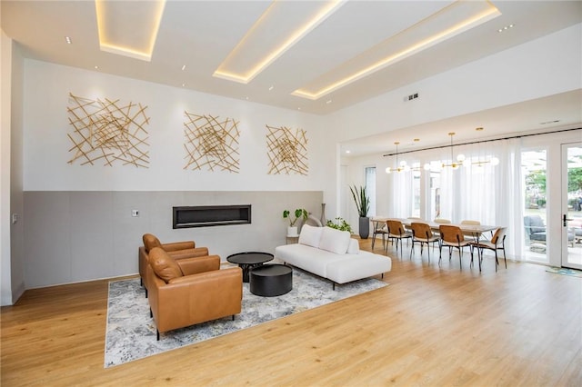 living room featuring a notable chandelier and light hardwood / wood-style flooring