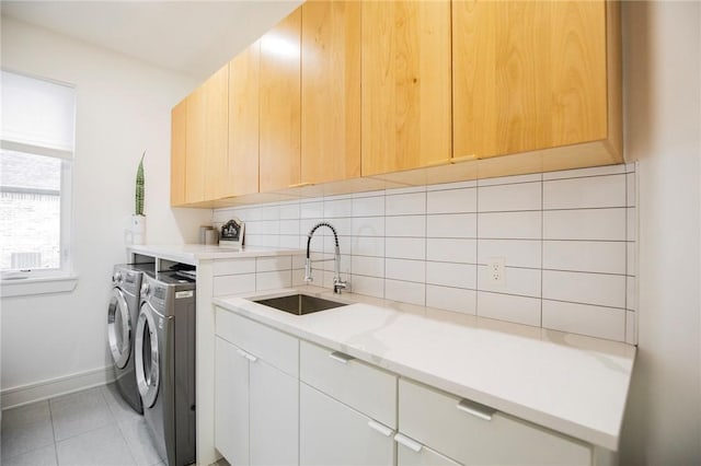 laundry area featuring cabinets, sink, and washer and clothes dryer