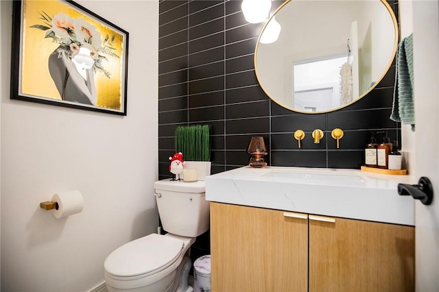 bathroom featuring tasteful backsplash, vanity, toilet, and tile walls