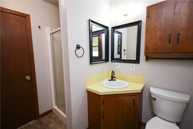 bathroom with an enclosed shower, vanity, and toilet