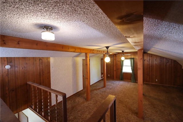 additional living space with vaulted ceiling, carpet floors, and a textured ceiling