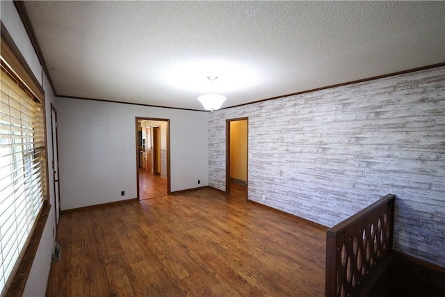 unfurnished bedroom with crown molding, dark hardwood / wood-style flooring, and a textured ceiling