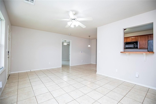 tiled spare room featuring ceiling fan