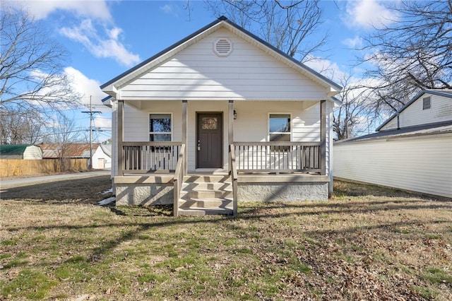 bungalow-style house featuring covered porch and a front yard