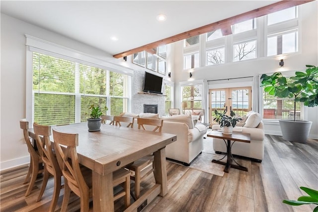 dining room featuring a brick fireplace, light hardwood / wood-style floors, and french doors