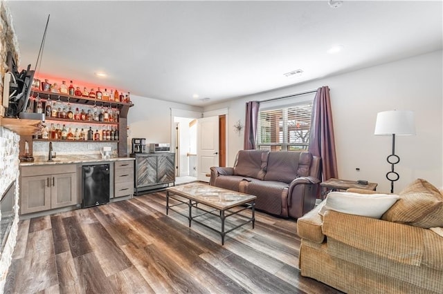 living room featuring dark hardwood / wood-style floors and indoor wet bar