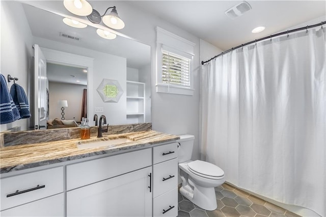 bathroom with tile patterned flooring, vanity, and toilet