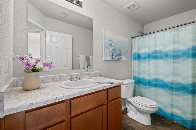 bathroom featuring hardwood / wood-style flooring, vanity, toilet, a textured ceiling, and a shower with curtain