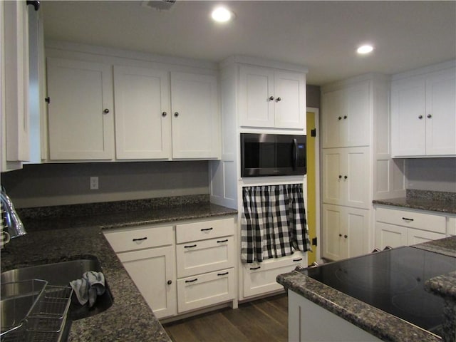 kitchen with white cabinetry, sink, dark stone countertops, and black appliances