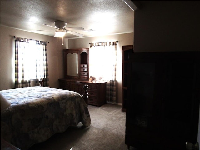 carpeted bedroom with a textured ceiling and ceiling fan