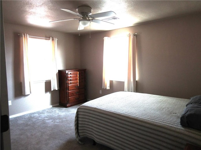 carpeted bedroom featuring a textured ceiling and ceiling fan