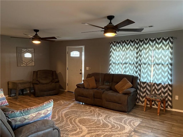 living area with visible vents, ceiling fan, and wood finished floors