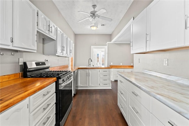 kitchen with ceiling fan, white cabinetry, butcher block counters, stainless steel appliances, and dark hardwood / wood-style flooring