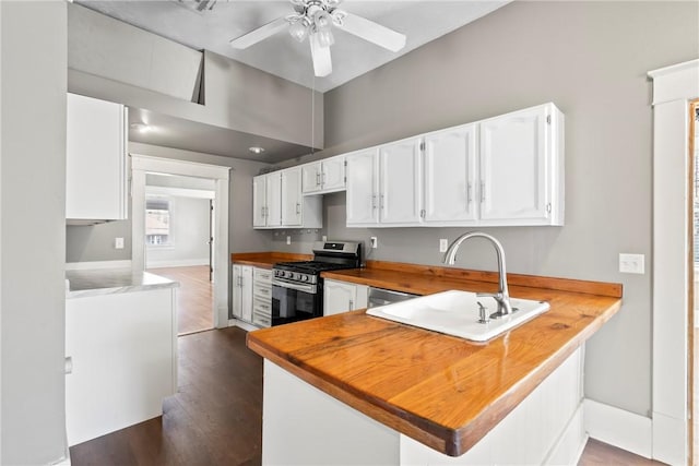 kitchen featuring sink, white cabinetry, stainless steel appliances, dark hardwood / wood-style flooring, and kitchen peninsula