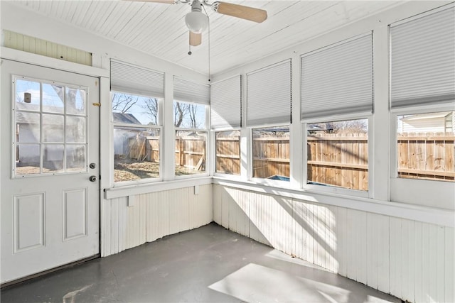 unfurnished sunroom with ceiling fan