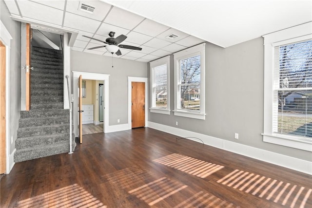 interior space featuring ceiling fan, a paneled ceiling, and dark wood-type flooring