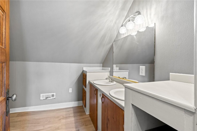 bathroom featuring lofted ceiling, hardwood / wood-style floors, and vanity
