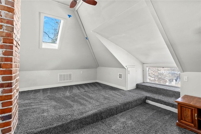 additional living space with lofted ceiling with skylight and dark carpet