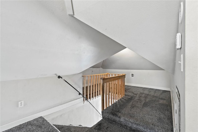 staircase featuring vaulted ceiling and carpet flooring