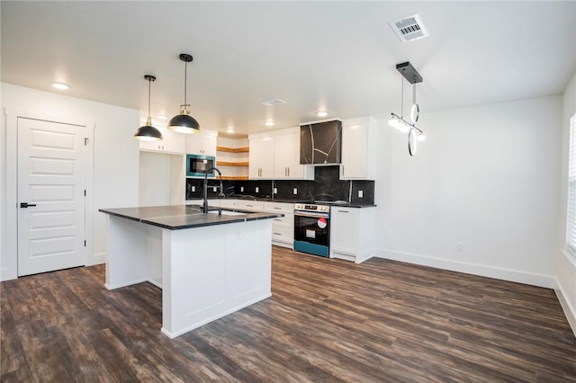 kitchen with built in microwave, sink, white cabinets, and decorative light fixtures