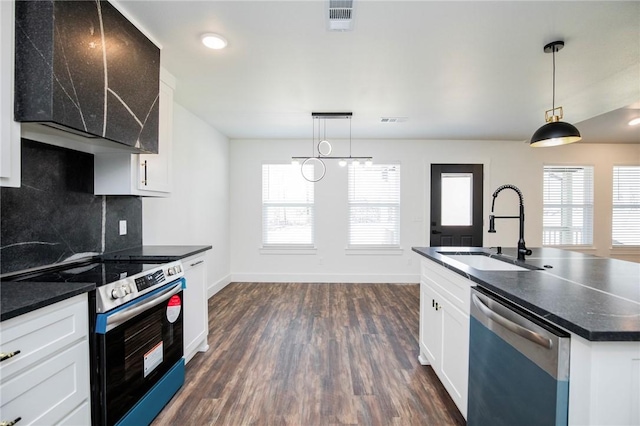 kitchen with sink, appliances with stainless steel finishes, white cabinetry, hanging light fixtures, and decorative backsplash