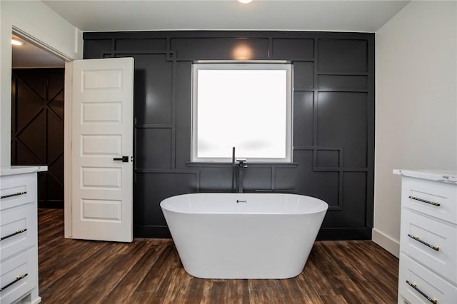 bathroom featuring wood-type flooring, a washtub, and vanity