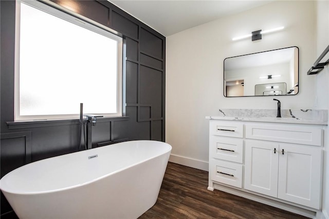 bathroom featuring vanity, a bath, and wood-type flooring