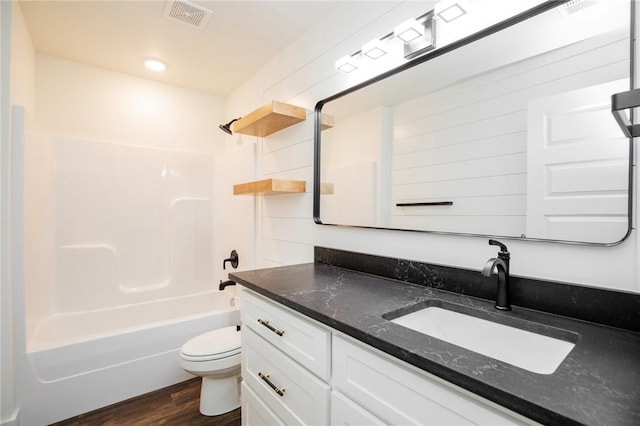 full bathroom with vanity, hardwood / wood-style flooring, shower / bathtub combination, and toilet