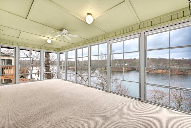 unfurnished sunroom featuring ceiling fan and a water view