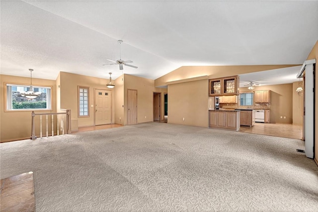 unfurnished living room featuring light carpet, ceiling fan with notable chandelier, and lofted ceiling