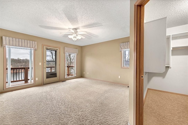 carpeted empty room featuring a textured ceiling and ceiling fan