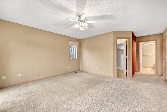 carpeted spare room with ceiling fan and a textured ceiling