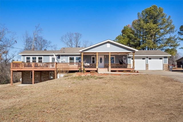 view of front facade with a garage, a wooden deck, and a front yard