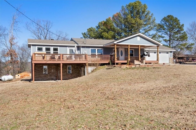 view of front of property featuring a garage, a deck, and a front lawn