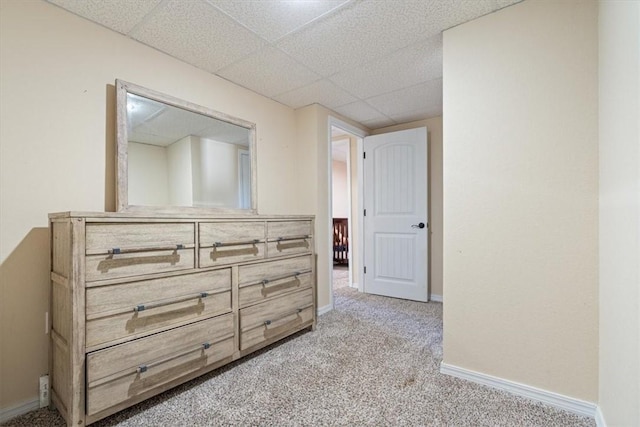 hallway with a drop ceiling and light colored carpet