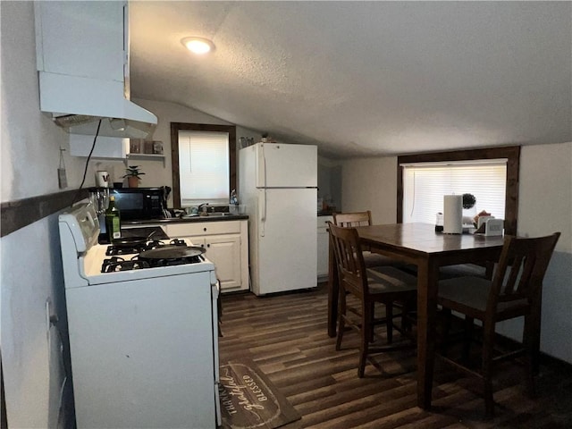 kitchen with white appliances, a textured ceiling, white cabinets, dark hardwood / wood-style flooring, and vaulted ceiling