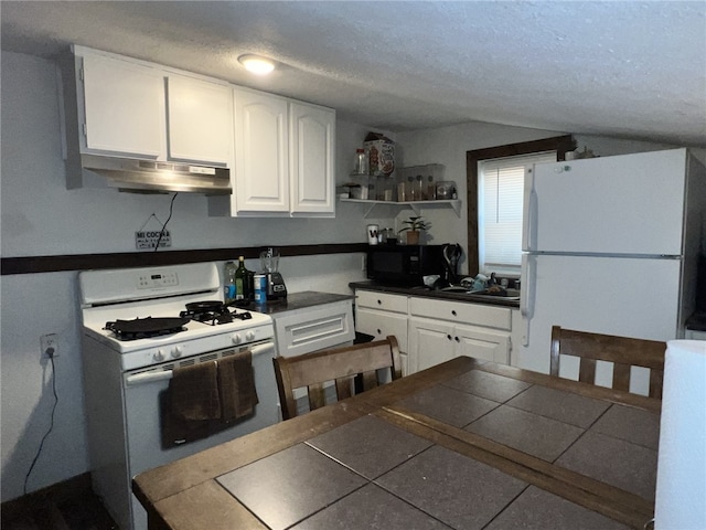 kitchen with sink, white cabinetry, a textured ceiling, tile counters, and white appliances