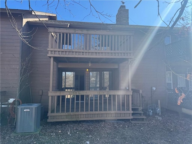 rear view of property featuring a balcony and central AC unit