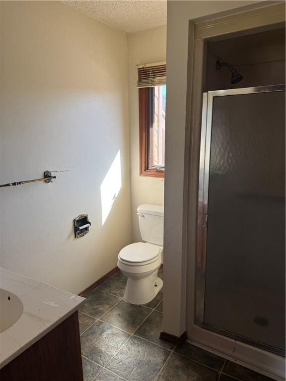 bathroom with vanity, an enclosed shower, a textured ceiling, and toilet