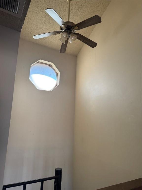 room details with ceiling fan and a textured ceiling