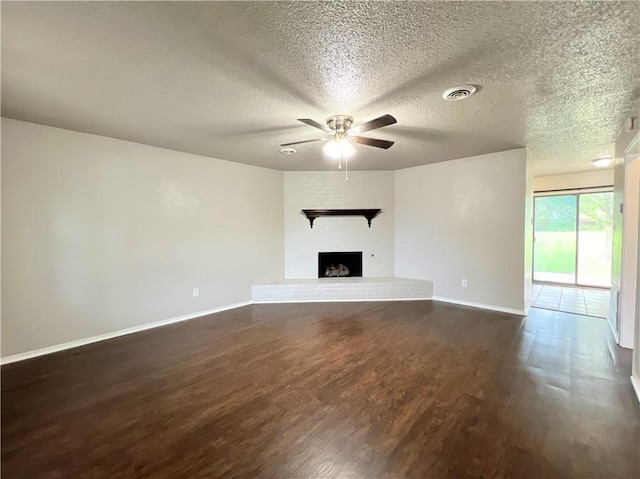 unfurnished living room with dark wood-type flooring, ceiling fan, and a textured ceiling