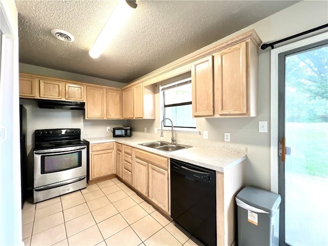 kitchen featuring light brown cabinetry, sink, light tile patterned floors, a healthy amount of sunlight, and black appliances