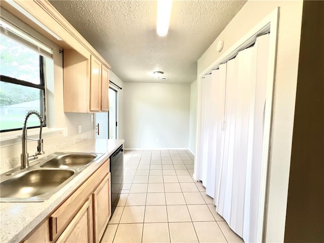 kitchen featuring sink, light tile patterned floors, dishwasher, a textured ceiling, and light brown cabinetry