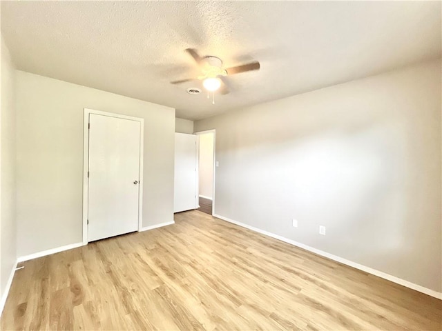 unfurnished bedroom with a textured ceiling, light hardwood / wood-style flooring, and ceiling fan