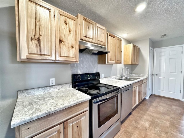 kitchen featuring sink, stainless steel appliances, tasteful backsplash, a textured ceiling, and light brown cabinets