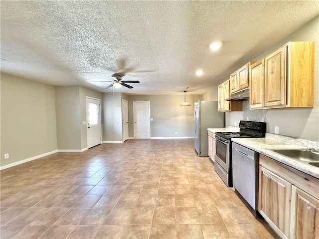 kitchen featuring stainless steel appliances, light brown cabinetry, a ceiling fan, light countertops, and a textured ceiling