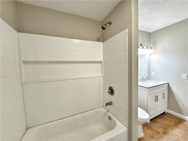 full bathroom featuring tile patterned flooring, tiled shower / bath combo, vanity, a textured ceiling, and toilet