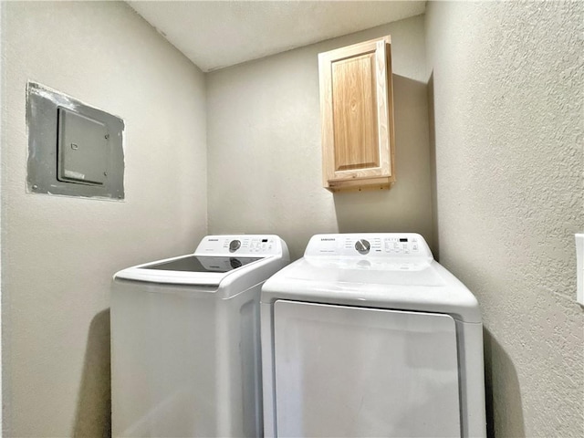 clothes washing area with cabinets, electric panel, and washing machine and dryer