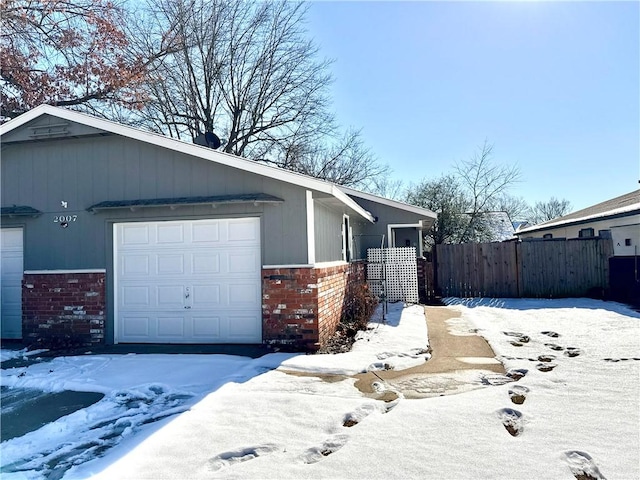 view of snowy exterior featuring a garage