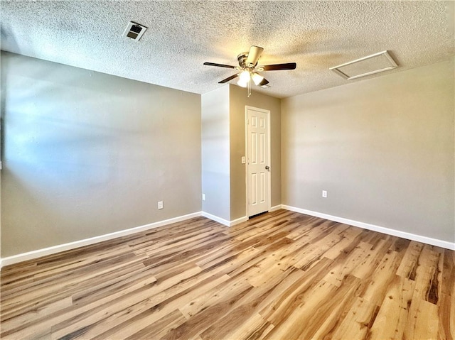 empty room with ceiling fan, a textured ceiling, and light hardwood / wood-style flooring